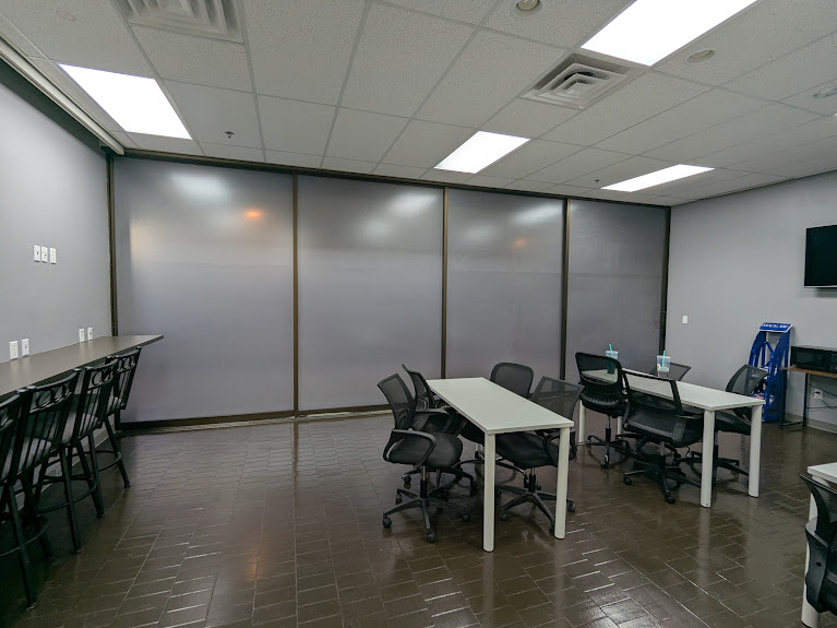 Shared office with desks and chairs beside frosted glass partitions
